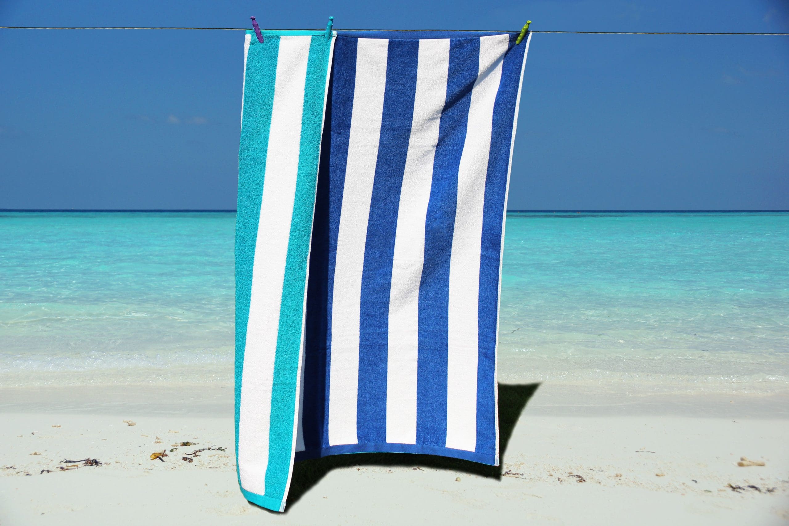 Blue and white striped luxury velour beach towel folded on a sun lounger