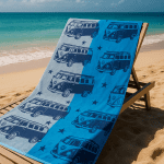 blue beach towel with camper van pattern at sunny beach on sunlounger