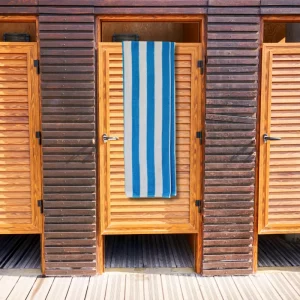 bright blue striped towel hanging over wooden door