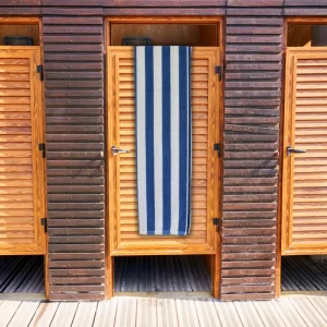 navy striped bath towel with blue and white stripes over wooden door