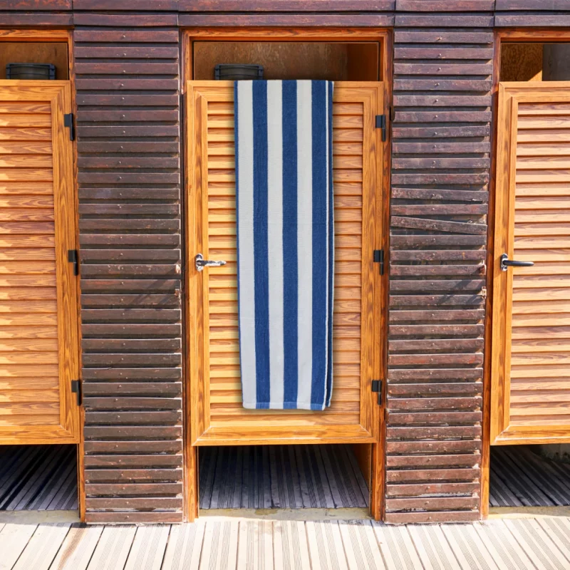 navy striped bath towel with blue and white stripes over wooden door