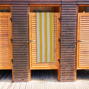 yellow striped towel. yellow & white stripe bath towel hanging over wooden door