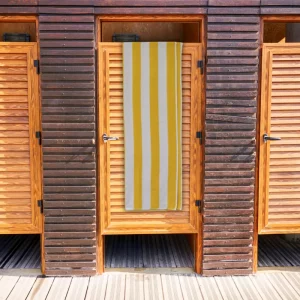 yellow striped towel. yellow & white stripe bath towel hanging over wooden door