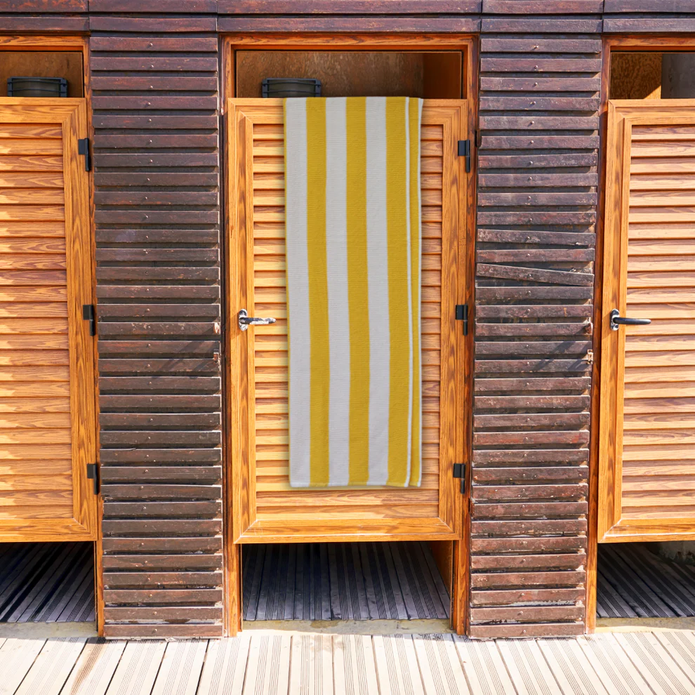 yellow striped towel. yellow & white stripe bath towel hanging over wooden door